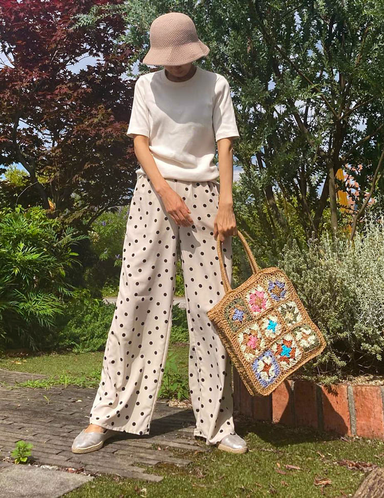 Geflochtene Strohtasche mit bunten Blumen